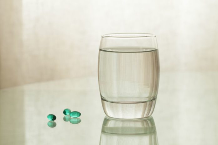 Medizinische Kapseln mit Wasserglas