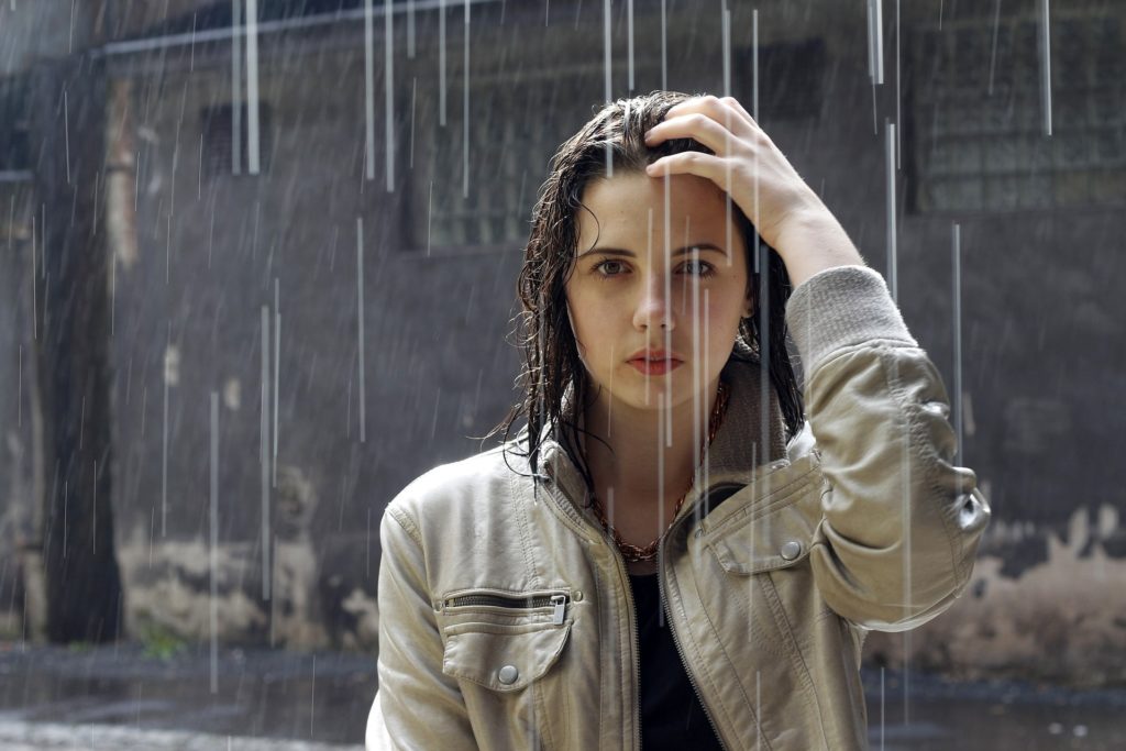 Frau steht im Regen